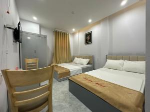 a small room with two beds and a chair at OYO 1190 Valentin Hotel in Da Nang