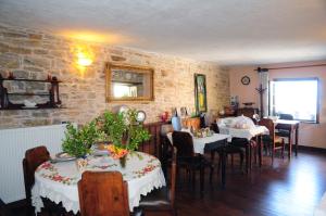 a dining room with two tables and a brick wall at Archontiko Parisis in Lafkos
