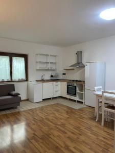 kuchnia z białymi urządzeniami i drewnianą podłogą w obiekcie La Casetta in Collina 2 w mieście Spoltore