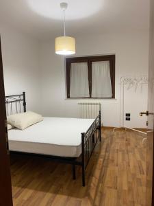 Łóżko w pokoju z drewnianą podłogą w obiekcie La Casetta in Collina 2 w mieście Spoltore