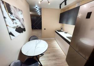 a small kitchen with a table and a refrigerator at Астана 18/1 in Ustʼ-Kamenogorsk
