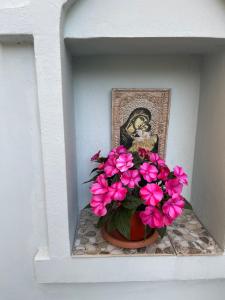 um vaso cheio de flores cor-de-rosa sentado numa prateleira em Casa Del Mare em Černomorec