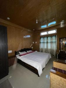a bedroom with a large bed in a room at Vamoose Sonam Guest House Tawang in Tawang