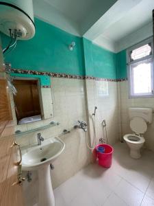 a bathroom with a sink and a toilet at Vamoose Sonam Guest House Tawang in Tawang