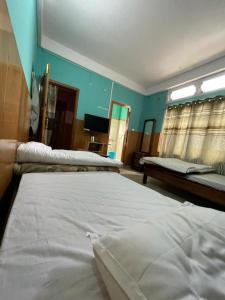 a bedroom with two beds and a mirror at Vamoose Sonam Guest House Tawang in Tawang