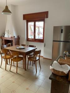 eine Küche mit einem Tisch und Stühlen sowie einem Kühlschrank in der Unterkunft Casa via Mare in Rocca Imperiale