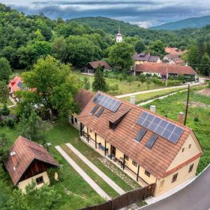 una vista aérea de una casa con paneles solares en el techo en Zuzmó Guesthouse, Jósvafő, Aggtelek National Park - Stylish 150 year old farmhouse for 10 guests, en Jósvafő