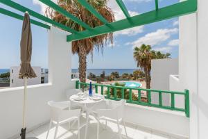 d'un balcon avec une table et des chaises et une vue sur l'océan. dans l'établissement Lanzahost Tuscan Atlantico, à Costa Teguise