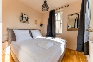 a bedroom with a bed with white sheets and a mirror at Traumhaftes Altstadt-Domizil in Marburg an der Lahn