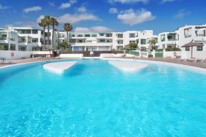 a large swimming pool in front of some buildings at Lanzahost Tuscan Atlantico in Costa Teguise
