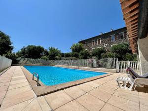 uma piscina num quintal com uma cadeira em Studio avec piscine em La Garde-Freinet