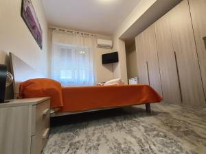 um quarto com uma cama laranja e uma janela em B&B SOLE E MARE em Rossano