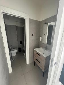 La salle de bains est pourvue d'un lavabo, d'une baignoire et de toilettes. dans l'établissement The Loft, à Milazzo