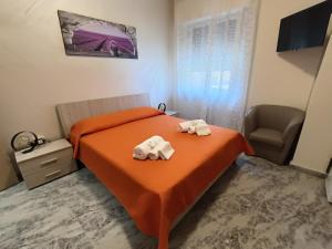 um quarto com uma cama laranja e toalhas em B&B SOLE E MARE em Rossano