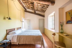 - une chambre avec un grand lit et un bureau dans l'établissement Agriturismo Casalino18, à Tognazza