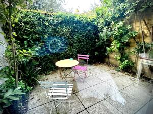a table and two chairs in a garden at Villa Etoile Cannes in Cannes