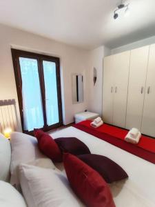 1 dormitorio con 1 cama blanca grande con almohadas rojas en Villetta di Anastasia en Filandari