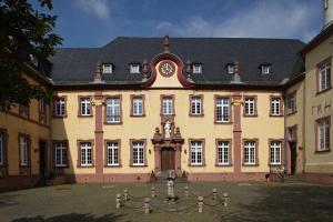 ein großes Gebäude mit einer Uhr auf der Vorderseite in der Unterkunft Kloster Steinfeld Gästehaus in Kall