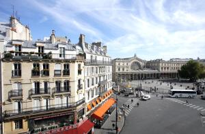 パリにあるリベルタル ガル ドゥ レスト フランセのバスや建物が並ぶ賑やかな街道