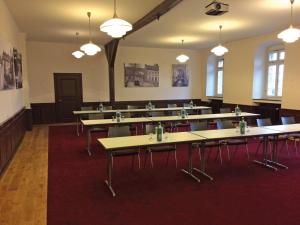 Habitación grande con mesas, sillas y luces. en Kloster Steinfeld Gästehaus, en Kall