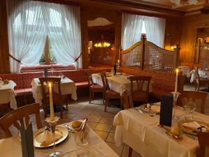 een restaurant met tafels en stoelen met witte tafelkleden bij Hotel Cima Rosetta - BW Signature Collection in San Martino di Castrozza