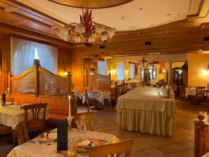 un restaurant avec deux tables à nappes blanches dans l'établissement Hotel Cima Rosetta - BW Signature Collection, à San Martino di Castrozza