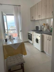 a kitchen with a table and a stove and a microwave at Διαμέρισμα στη Ναύπακτο in Nafpaktos