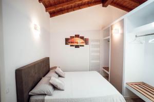 a bedroom with white walls and a bed with pillows at Corte Isabel in Costermano