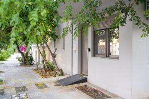 a white building with a window and trees at Lion's Cave suite No 1. in Kalamata