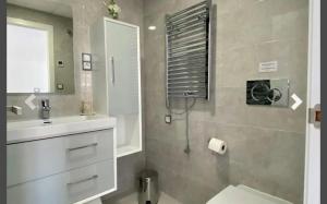a bathroom with a sink and a toilet and a mirror at MyFlats Infinity View in Arenales del Sol