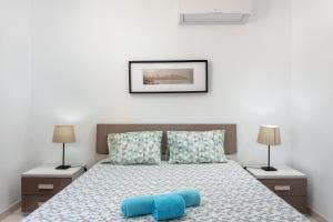 ein Schlafzimmer mit einem Bett mit zwei blauen Kissen in der Unterkunft Fresh Sunny Flat with Pool & Terrace by Host Wise in Olhos de Água