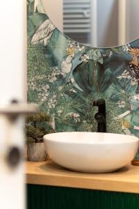 um lavatório em cima de um balcão com um padrão de flores em Emerald Apartment em Baia Mare