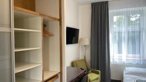 a room with a bedroom with a bed and a window at Aparthotel Slezák in Litomyšl