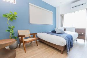 a bedroom with blue walls and a bed and a chair at NEW! Pufuka Hikifune｜120㎡ (2 floors)｜Max 15 people in Tokyo