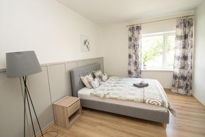 Un dormitorio con una cama con una lámpara y una ventana. en Kerese Apartments, en Pärnu