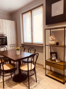 ein Esszimmer mit einem Tisch und Stühlen sowie eine Küche in der Unterkunft Corte 22 B&b e Appartamenti in Borgomanero