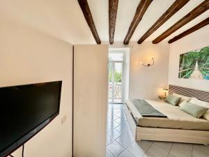 a living room with a bed and a flat screen tv at Loft Università 4 posti letto in Bergamo