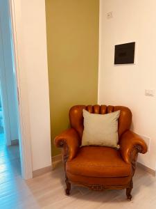 a brown leather chair with a pillow in a room at Corte 22 B&b e Appartamenti in Borgomanero