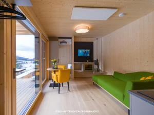 a living room with a green couch and a table at Wiesenquartier I Chalet I Adults only in Langenwang