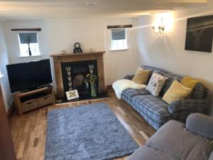 a living room with a couch and a fireplace at Cherry Tree Cottage Close to Belvoir Castle. Sleeps 6. Dogs v welcome. in Redmile