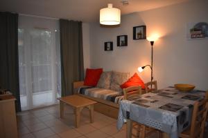 a living room with a couch and a table at Les Dunes 6 personnes, piscines, proche de la plage in Ondres