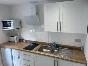 a kitchen with a sink and a microwave at Acorn Lodge in Eastergate