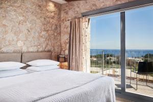 ein Schlafzimmer mit einem Bett und einem großen Fenster in der Unterkunft Luxury Rhodes Villa - Amel Villa - Stunning Sea Views - Private Swimming Pool - 3BDR - Kalithea in Koskinou