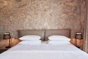 ein Schlafzimmer mit einem Bett mit zwei Lampen in der Unterkunft Luxury Rhodes Villa - Amel Villa - Stunning Sea Views - Private Swimming Pool - 3BDR - Kalithea in Koskinou