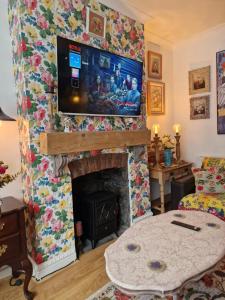 sala de estar con chimenea y TV encima. en Town Cottage ground floor appartment en Bridgend