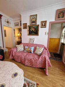 uma sala de estar com um sofá rosa com almofadas em Town Cottage ground floor appartment em Bridgend