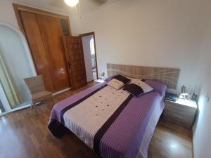 a bedroom with a large bed with a purple blanket at Cabo de Palos VVMU 4780-1 in Cabo de Palos