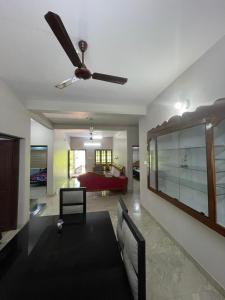 a living room with a ceiling fan and a couch at Nisara Homestay in Varkala