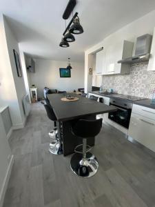 a kitchen with a black table and black chairs at Taïcyté Beg Meil in Fouesnant +14 photos
