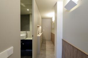 een witte badkamer met een wastafel en een spiegel bij Aspasios Bonjardim Apartments in Porto +26 foto's